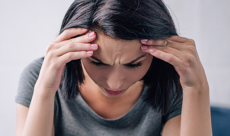 Depressed woman holding her head