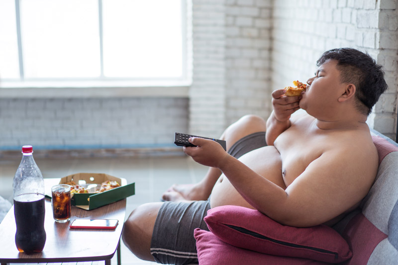 Fat man eating pizza